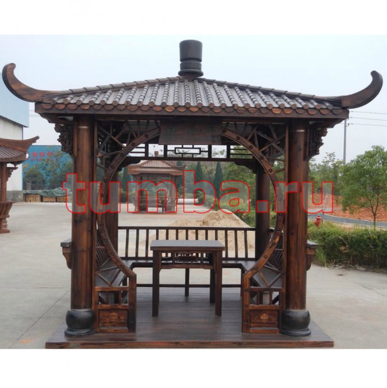 Китайская беседка для дачи с круглыми стойками, резным декором и комплектом деревянной мебели.
